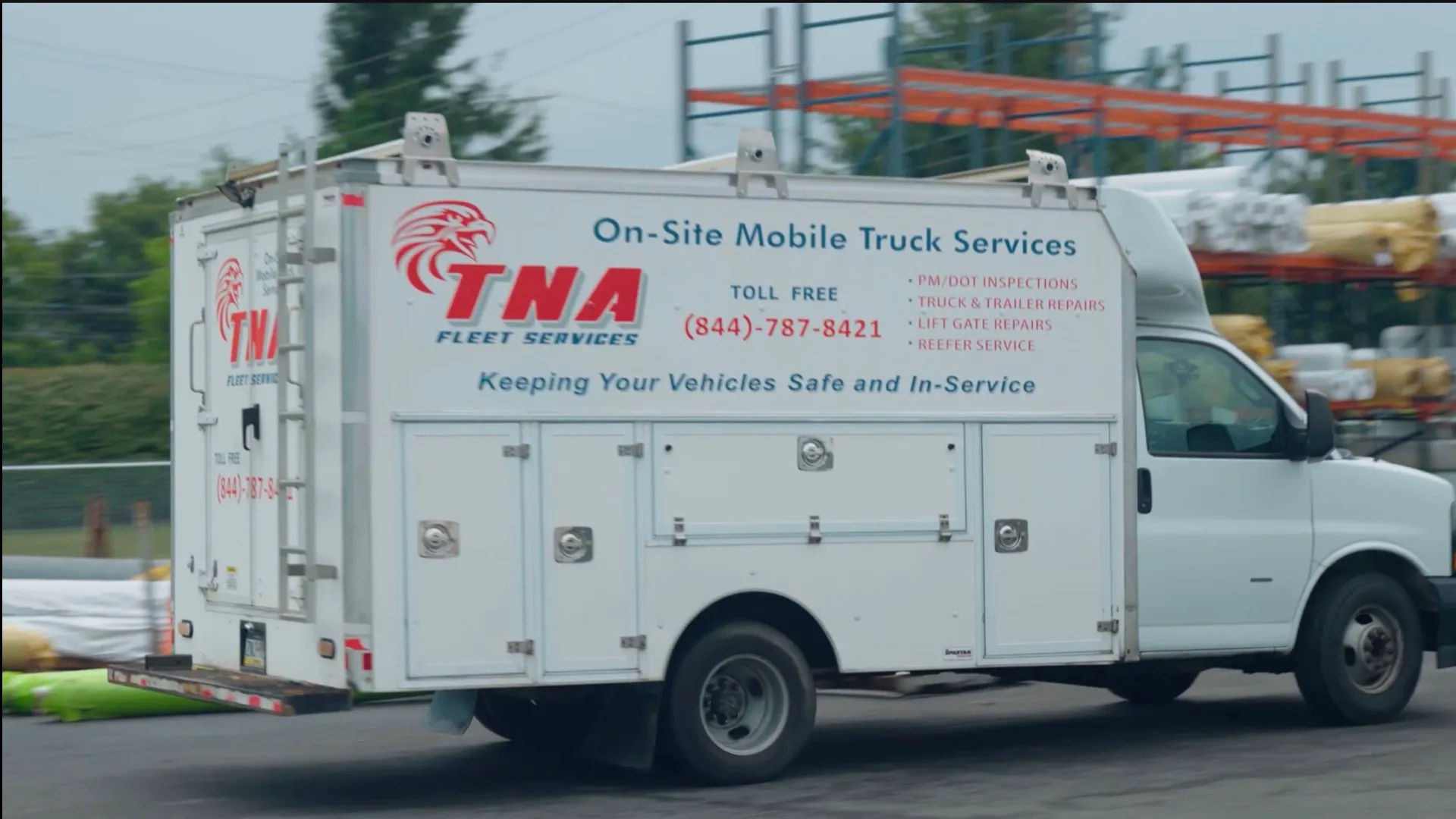 The side panel of a TNA service truck: eagle logo, toll-free number, and a list of services